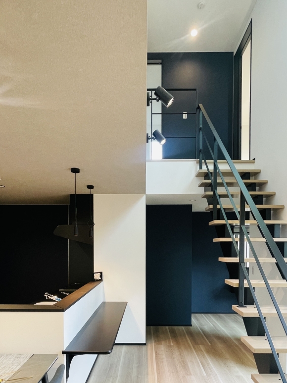 吹抜けとスケルトン階段、アクセントの壁紙と配色。インパクトがあるデザインの中に安らぎも感じる空間です。