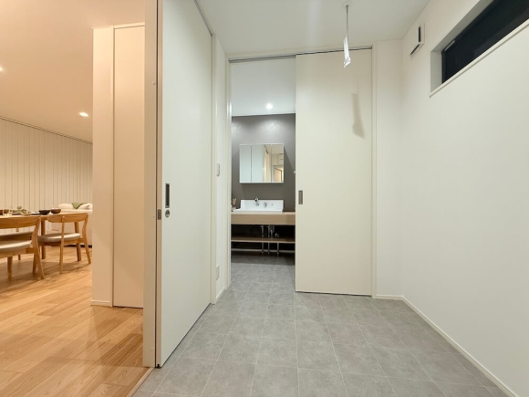 タイル調の床材で統一された水回り空間。回遊性の高い動線設計が、使いやすさと快適さを両立しています。