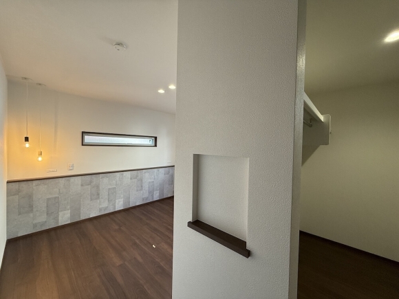 寝室は、腰壁を付けて空間にアクセント。頭元にスマホも置けて、デザインと機能性を両立。