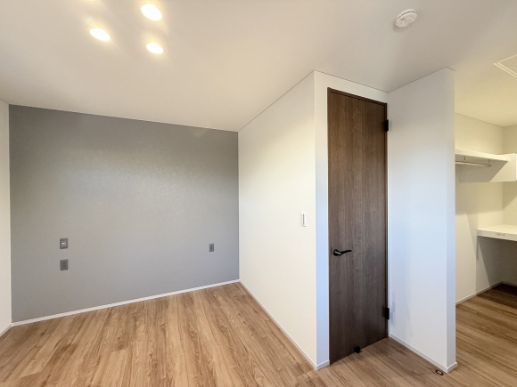 アクセントクロスがモダンな雰囲気の主寝室。奥にはオープンタイプのウォークインクローゼットを備えています。