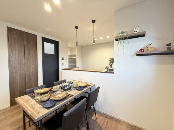 キッチン横のダイニングスペース。アクセントの棚とペンダントライトが、おしゃれなカフェのような雰囲気を演出します。