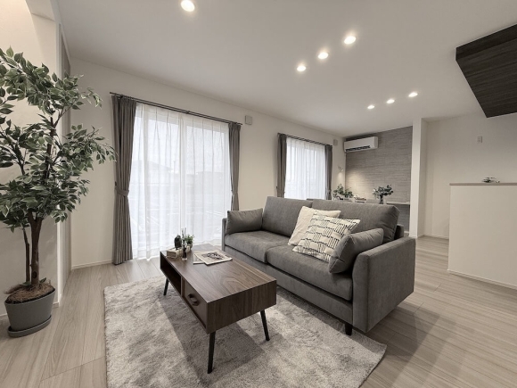 大きな窓から光が差し込む明るいLDK。木目×グレーで落ち着いた上質な空間に