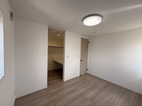 大容量WICを備えた洋室。木の温もりが広がる、心地よいプライベート空間。