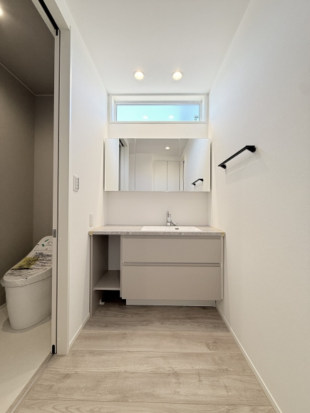 横長の窓から光が差し込む洗面スペース。おしゃれな造作洗面台で日々の身支度も快適です。