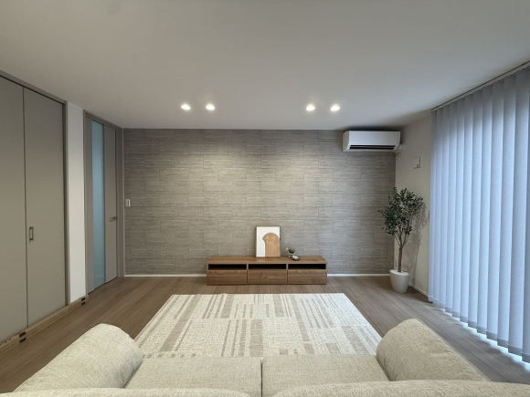 石目調のアクセントクロスが印象的。シンプルな空間に上質な落ち着きをプラス。
